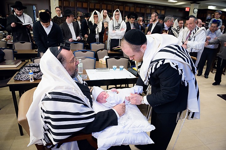 Rabbi Shmuel Katz preparing to perform a brit milah with family and friends gathered around.